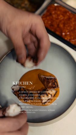 Hand plating a gourmet dish with three portions on a round plate in a fine dining setting.